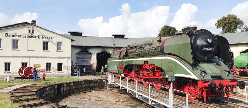 große imposante grüne WFL Dampflok 02 0201-0 mit rotem Fahrwerk steht auf dem Drehkreuz im Bahnbetriebswerk Nossen